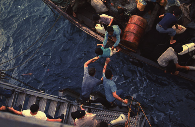Crewmen of the USS Durham take Vietnamese refugees aboard.