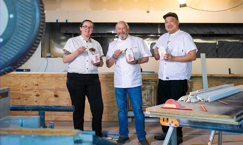 Chef Kaya Rehnberg, Owner Eric Scheffer, and Chef Ray Hui sample food from Chinese takeout boxes inside The Majestic.
