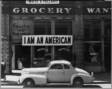 "I am an American" sign in front of the White & Pollard Grocery storefont